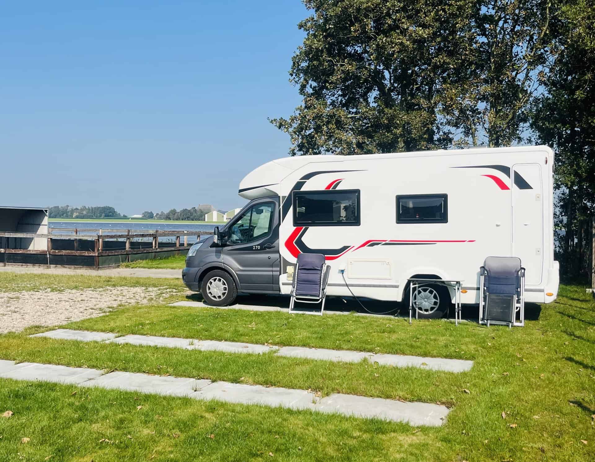 Camper op een camperplaats met uitzicht over het water